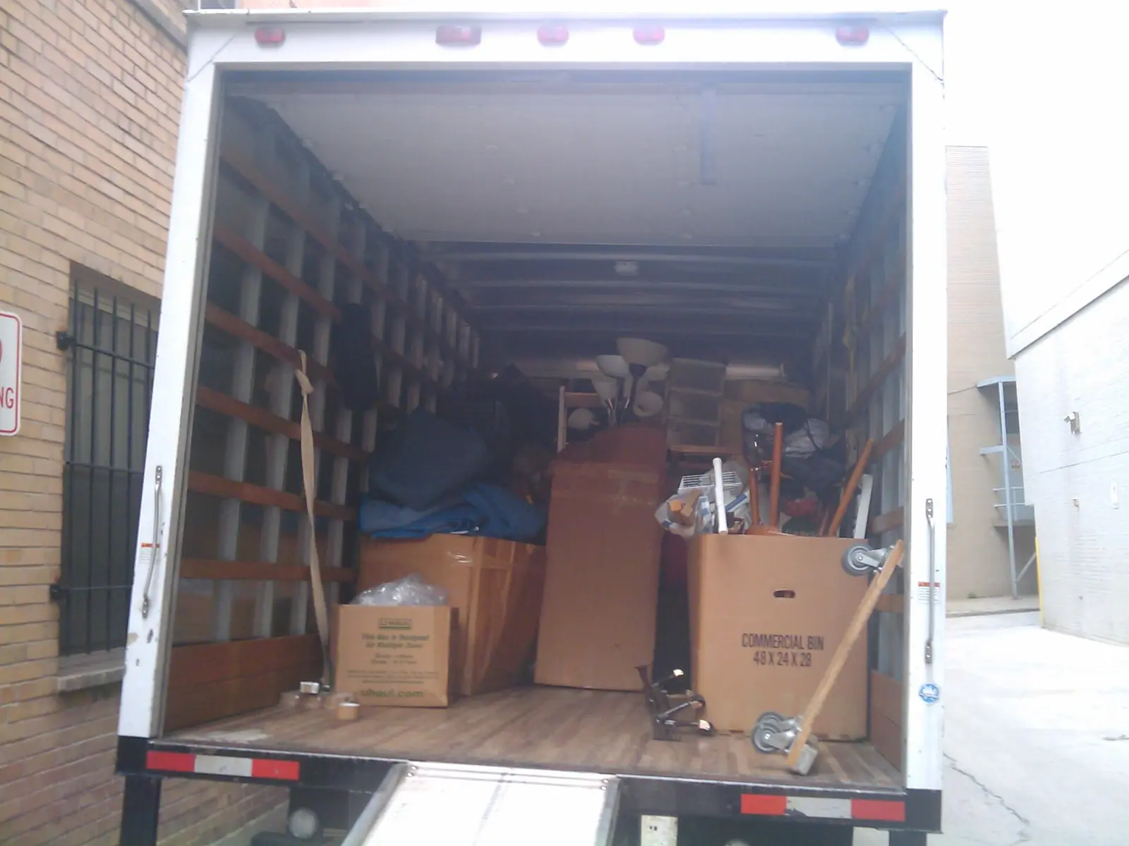 Cardboard boxes and furniture loaded into the back of a moving truck